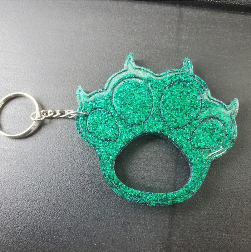 Self defense cat claw key chain with green and blue glitter.